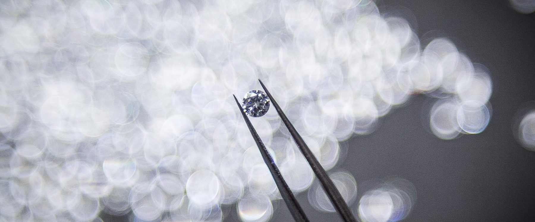 A stone held with tweezers under inspection